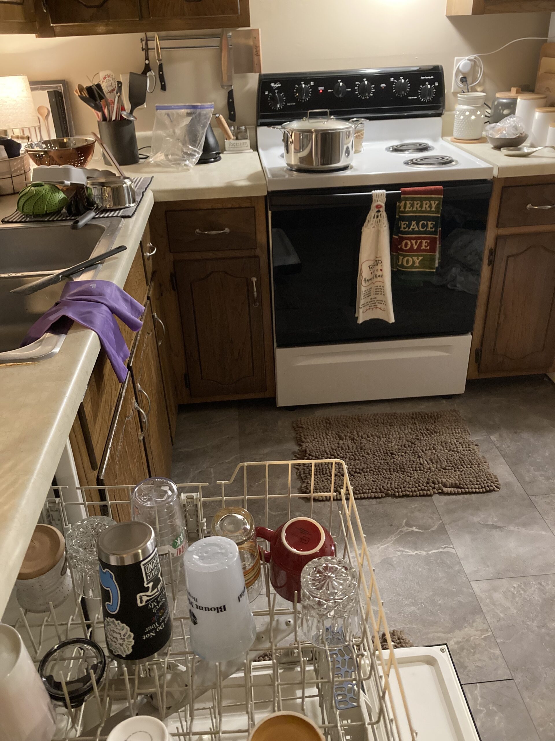 Cozy lamp lit kitchen. With food cooking on stove, and clean dishes ready to be put away. Photo credit: Kati Kirst