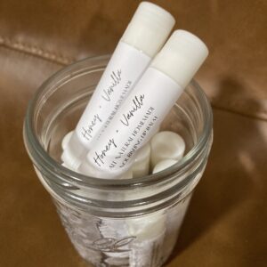 Lip balms in mason jar on tan leather