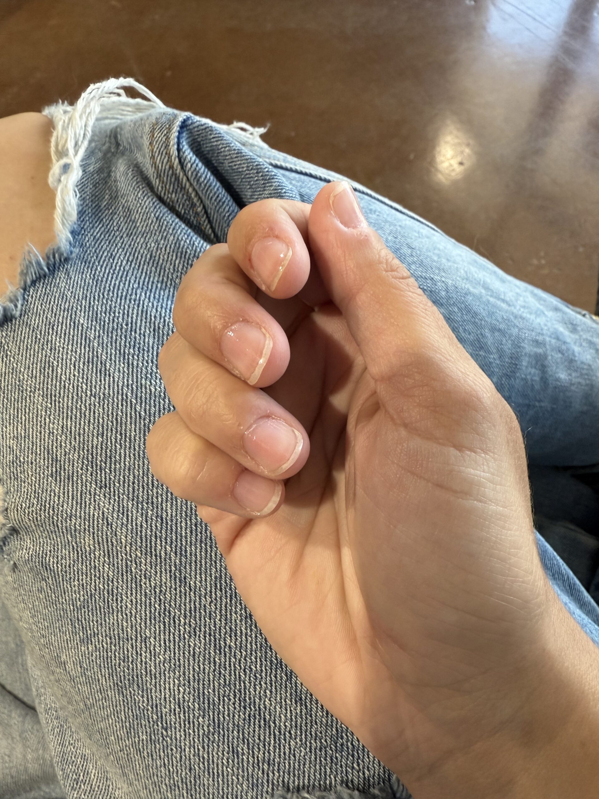 hand laying on jeans, focus on finger nails Photo Credit: Kati Kirst
